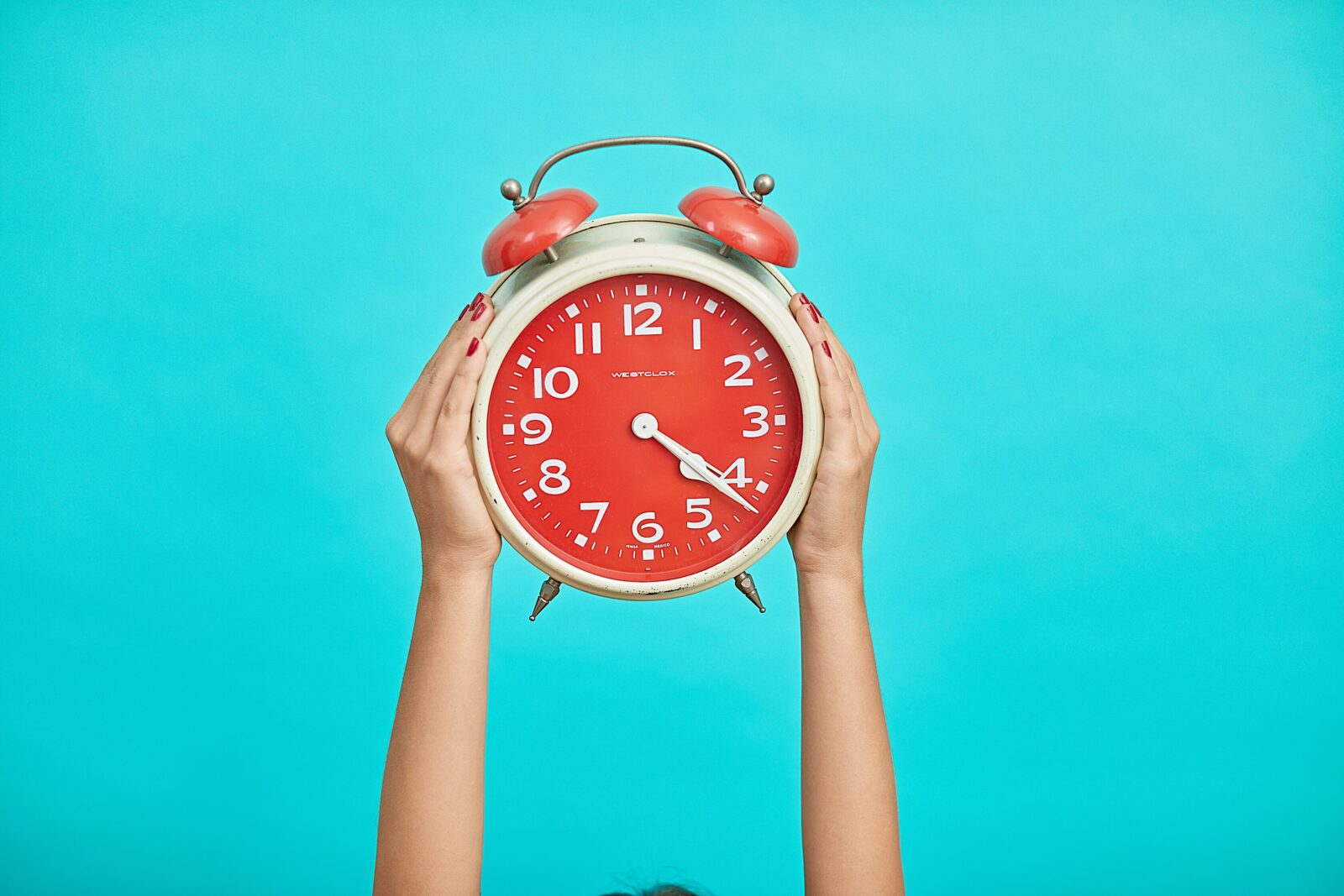 Hands holding an alarm clock